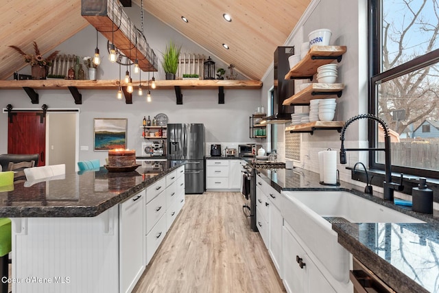 kitchen with open shelves, wood ceiling, light wood-type flooring, appliances with stainless steel finishes, and a sink