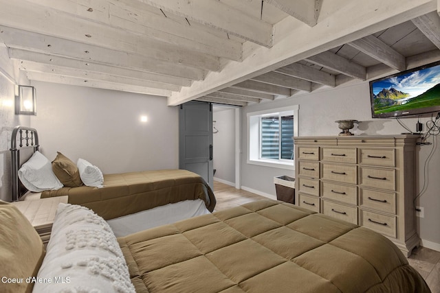 bedroom featuring beam ceiling, baseboards, and light wood-style floors