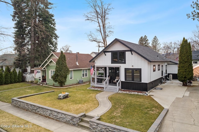 view of front of property featuring driveway, a shingled roof, and a front lawn