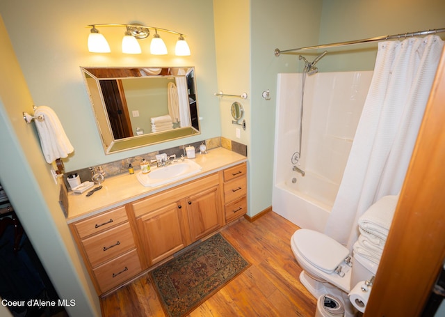 bathroom with shower / bathtub combination with curtain, toilet, wood finished floors, and vanity