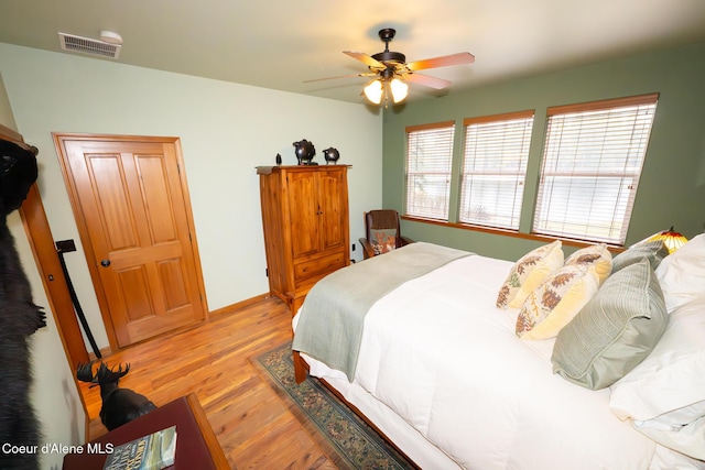 bedroom with light wood-style flooring, visible vents, and ceiling fan