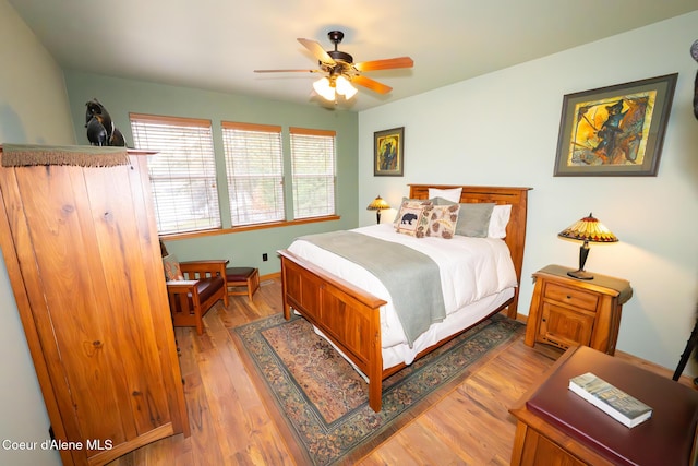 bedroom with light wood-type flooring, baseboards, and ceiling fan