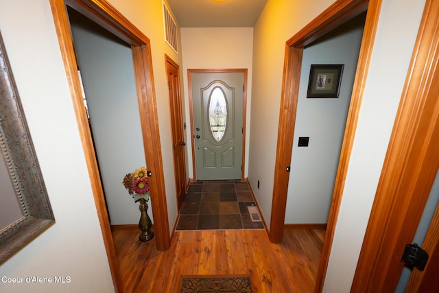 doorway to outside featuring wood finished floors, visible vents, and baseboards