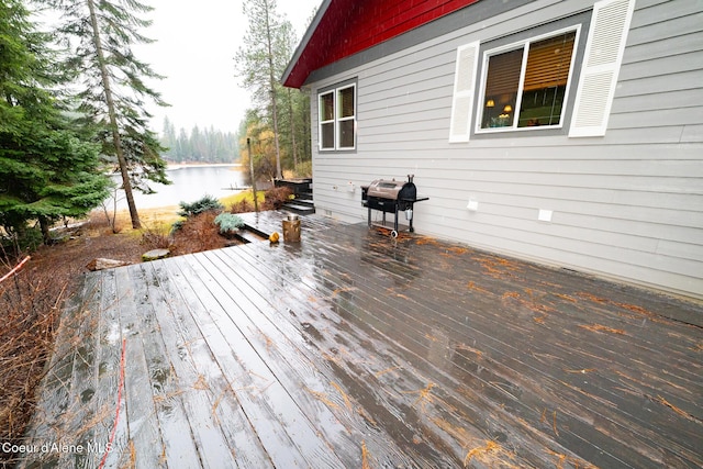 wooden deck with area for grilling and a water view