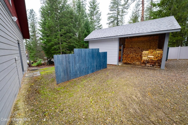 view of yard featuring an outdoor structure and fence