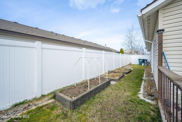 view of yard with a vegetable garden and a fenced backyard