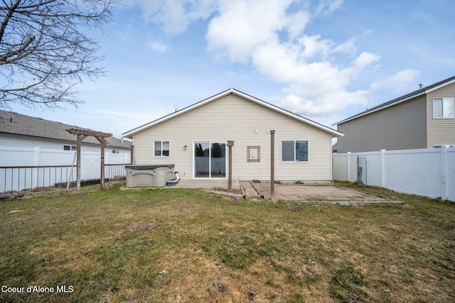 rear view of house featuring a pergola, a patio, a fenced backyard, a yard, and a hot tub