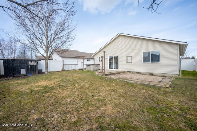 rear view of house with a yard, a fenced backyard, and a patio