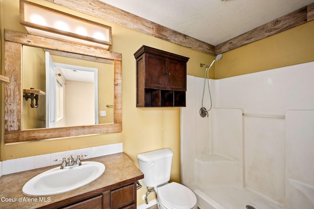 full bathroom featuring vanity, toilet, a shower, and a textured ceiling