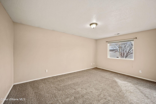 carpeted empty room with visible vents, baseboards, and a textured ceiling