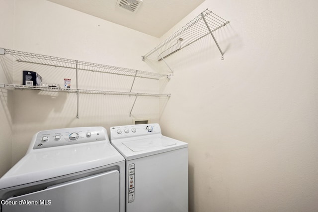 clothes washing area featuring visible vents, laundry area, and separate washer and dryer