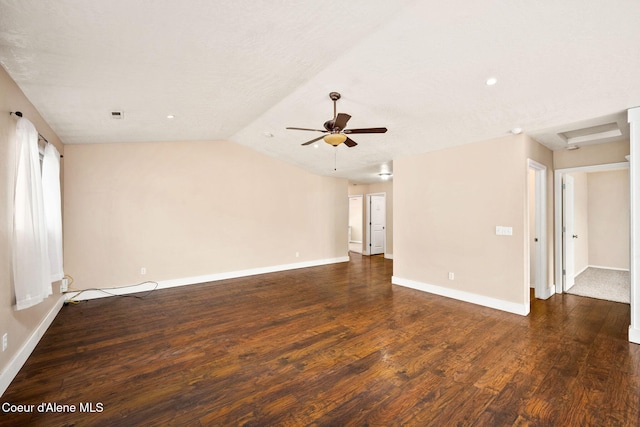 spare room featuring wood finished floors, baseboards, attic access, ceiling fan, and vaulted ceiling