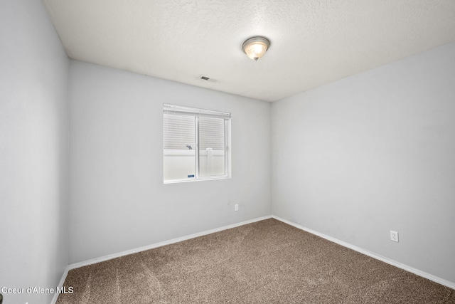 empty room featuring visible vents, carpet floors, a textured ceiling, and baseboards