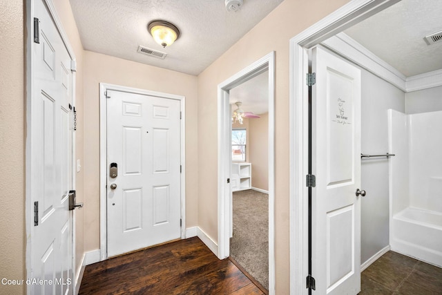 entrance foyer with visible vents, baseboards, a textured ceiling, and dark wood-style floors