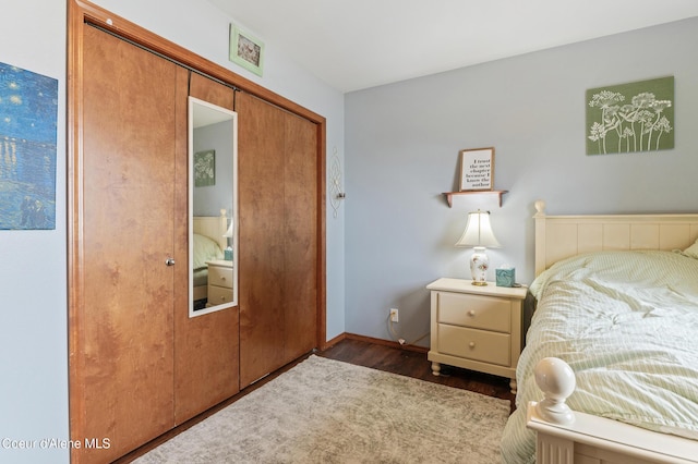 bedroom featuring dark wood-style floors, a closet, and baseboards