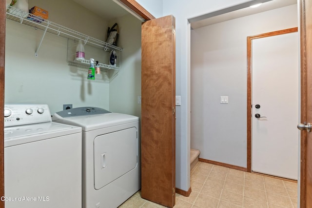 clothes washing area with baseboards, laundry area, and washing machine and clothes dryer