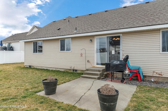 rear view of house with a patio area, a yard, fence, and roof with shingles