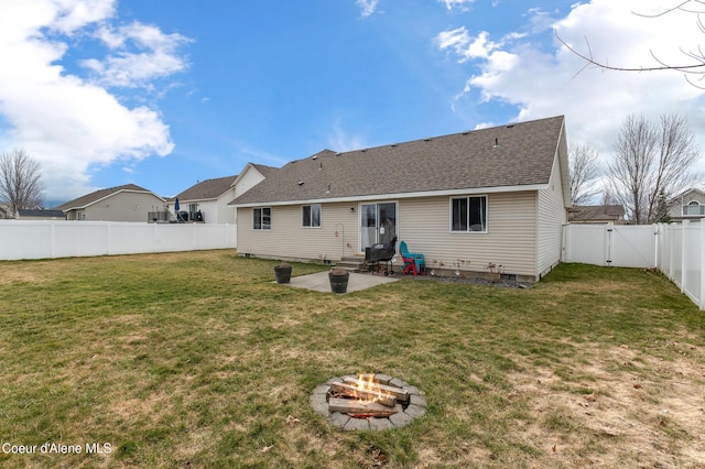 rear view of property with a gate, a fenced backyard, a yard, a fire pit, and a patio area