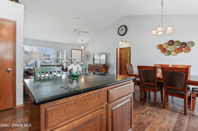 kitchen featuring arched walkways, dark wood-style floors, ceiling fan with notable chandelier, and lofted ceiling