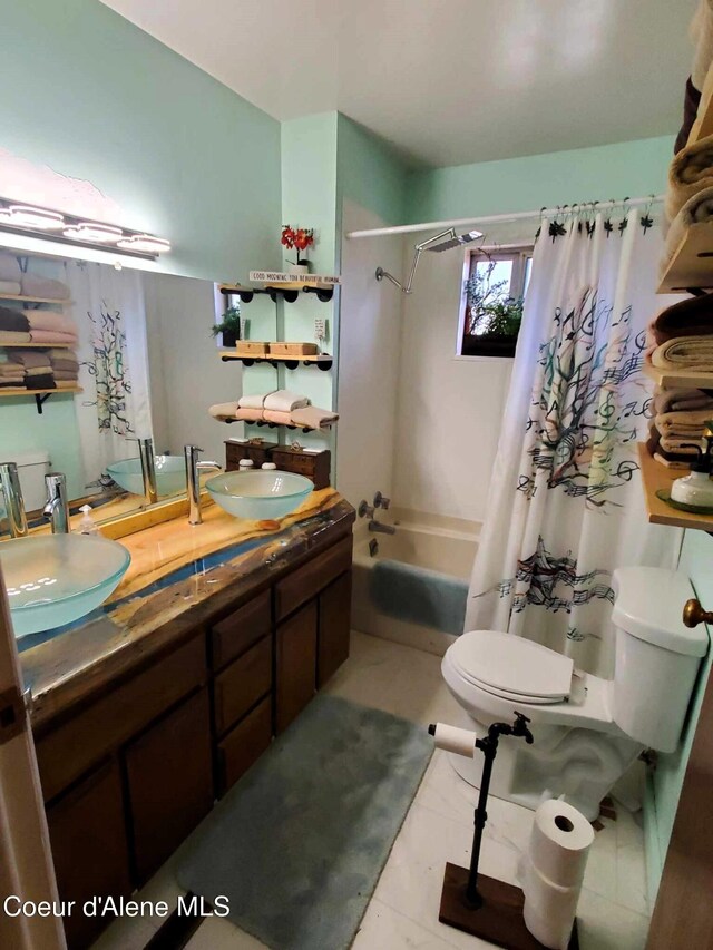 full bathroom with double vanity, toilet, shower / tub combo, and a sink