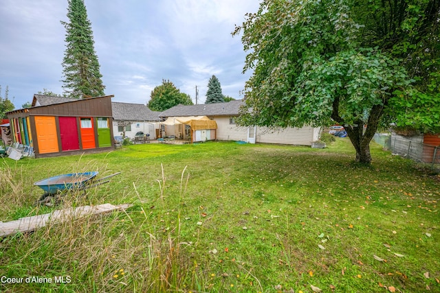 view of yard featuring an outdoor structure and fence