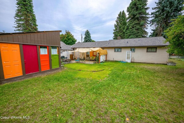 rear view of property with an outbuilding and a yard