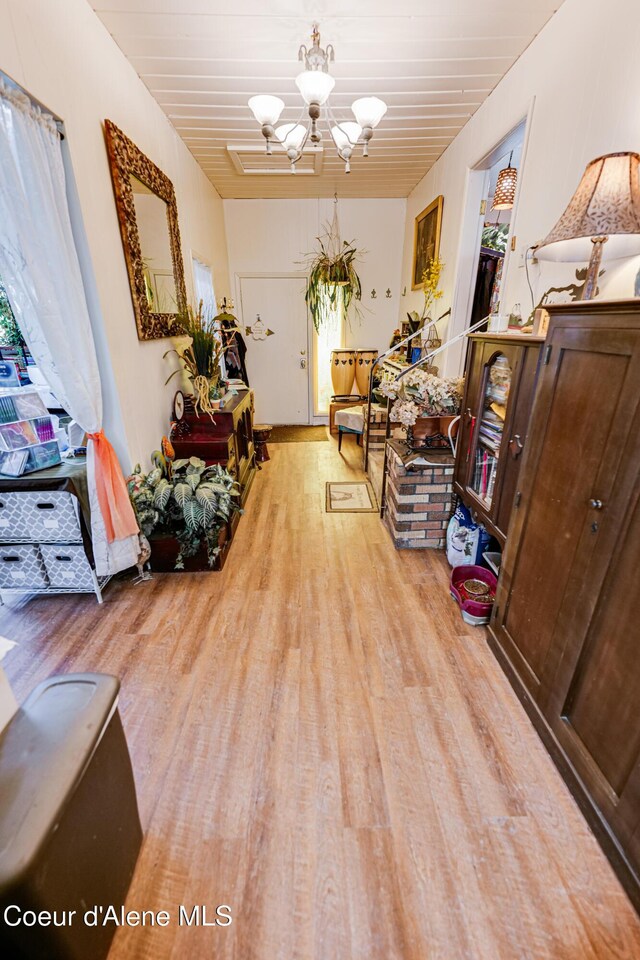 interior space with a chandelier, wood ceiling, and wood finished floors