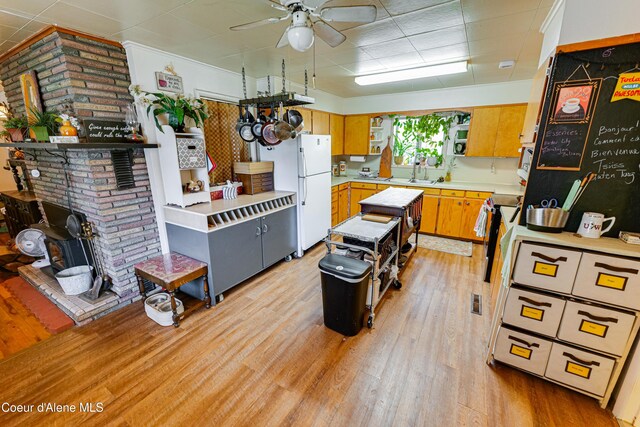 kitchen with light countertops, light wood-style flooring, freestanding refrigerator, and stainless steel range with electric cooktop