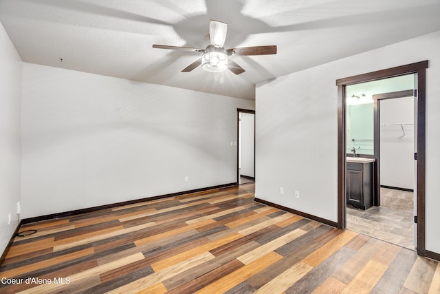 spare room featuring baseboards, a ceiling fan, and light wood finished floors