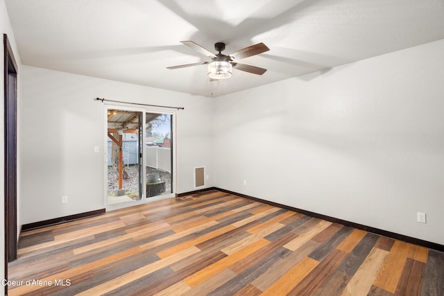 spare room with visible vents, wood finished floors, baseboards, and ceiling fan