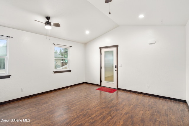 unfurnished room featuring a wealth of natural light, lofted ceiling, ceiling fan, and wood finished floors