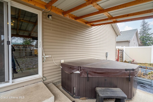 view of patio / terrace featuring fence and a hot tub