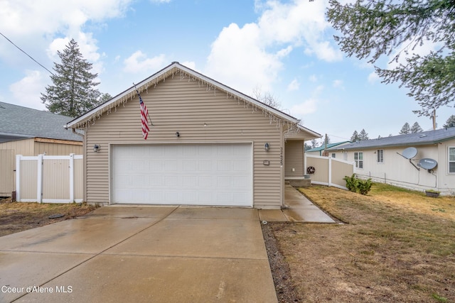 view of front of home with a front lawn, fence, and a garage