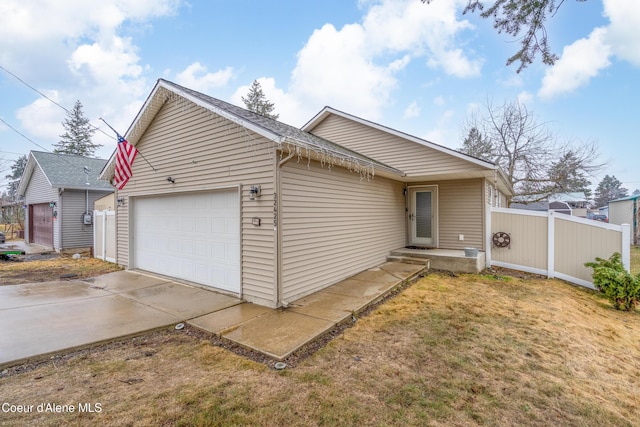 ranch-style home featuring a garage, driveway, and fence