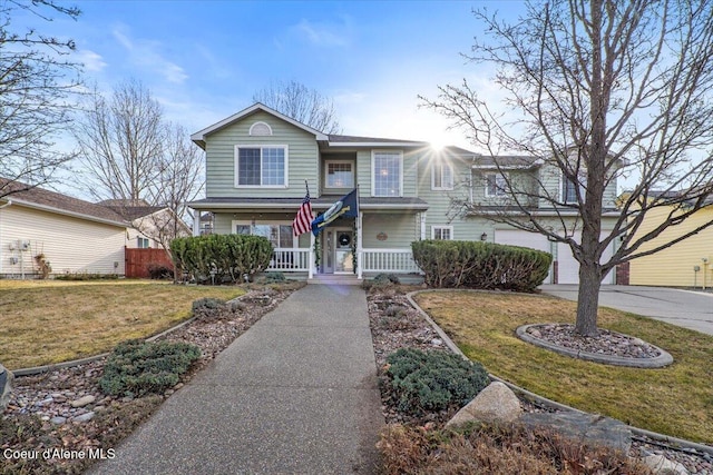 view of front of property featuring concrete driveway, covered porch, and a front lawn