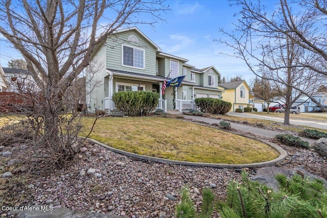 traditional-style house featuring a front lawn, a residential view, and driveway