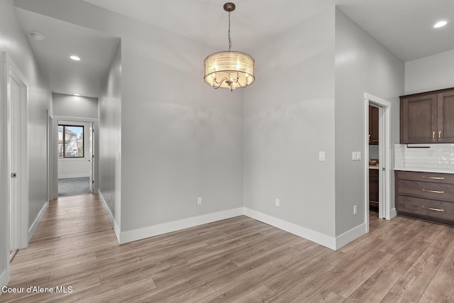 unfurnished dining area with recessed lighting, baseboards, and light wood-style floors