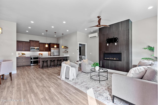 3016 N Casa Ct, Coeur Dalene, ID 83814 - living area with a wall mounted AC, light wood-style flooring, recessed lighting, ceiling fan, and a fireplace