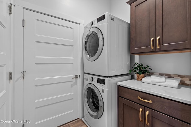 3016 N Casa Ct, Coeur Dalene, ID 83814 - laundry room featuring stacked washer / dryer, cabinet space, and light wood-type flooring