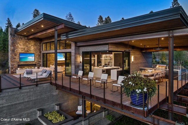 deck featuring area for grilling and ceiling fan