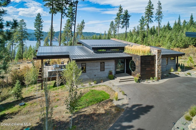 contemporary home featuring driveway, metal roof, and a standing seam roof