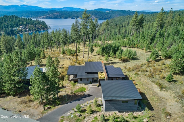 drone / aerial view featuring a water and mountain view and a wooded view