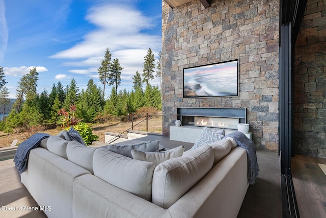 living area featuring wood finished floors and an outdoor stone fireplace