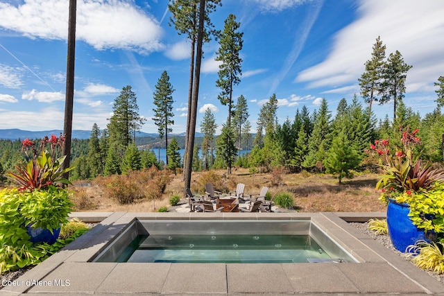 view of swimming pool with an in ground hot tub and a mountain view