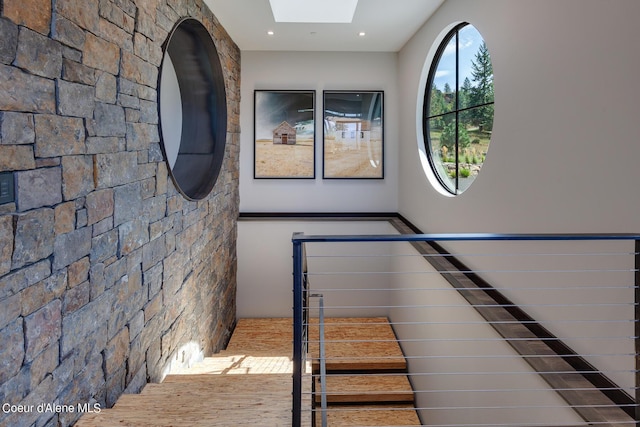 stairs with a skylight and recessed lighting