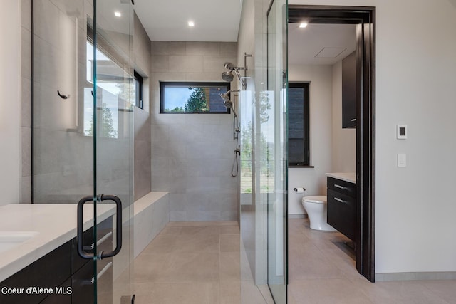 full bath with vanity, baseboards, a stall shower, tile patterned floors, and toilet