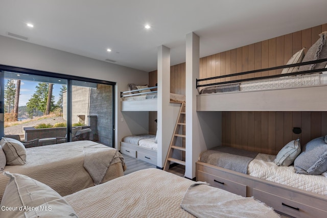 bedroom featuring wooden walls, recessed lighting, wood finished floors, and visible vents