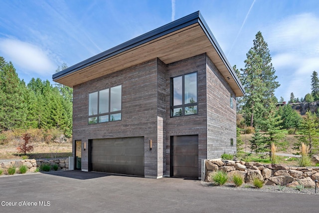 view of property exterior with an attached garage and driveway