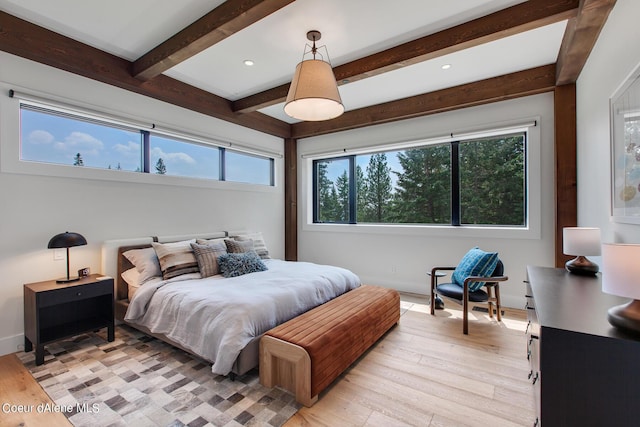 bedroom with baseboards, light wood-type flooring, multiple windows, and beam ceiling