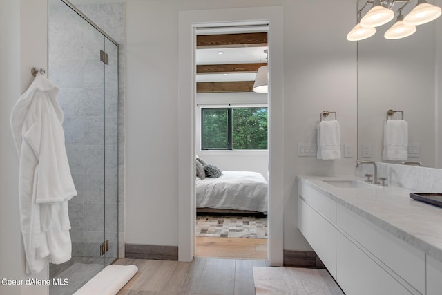 ensuite bathroom featuring a shower stall, connected bathroom, beam ceiling, wood finished floors, and vanity